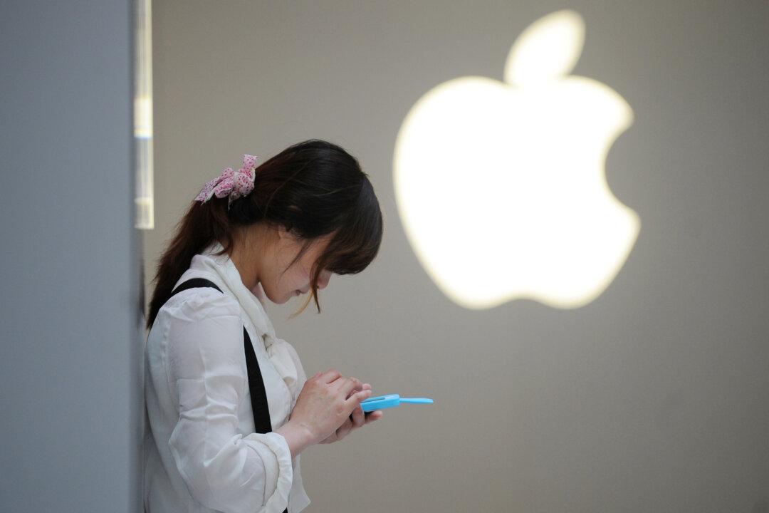 A woman uses her mobile phone outside an Apple store in Shanghai on May 7, 2012. (Peter Parks/AFP/Getty Images)