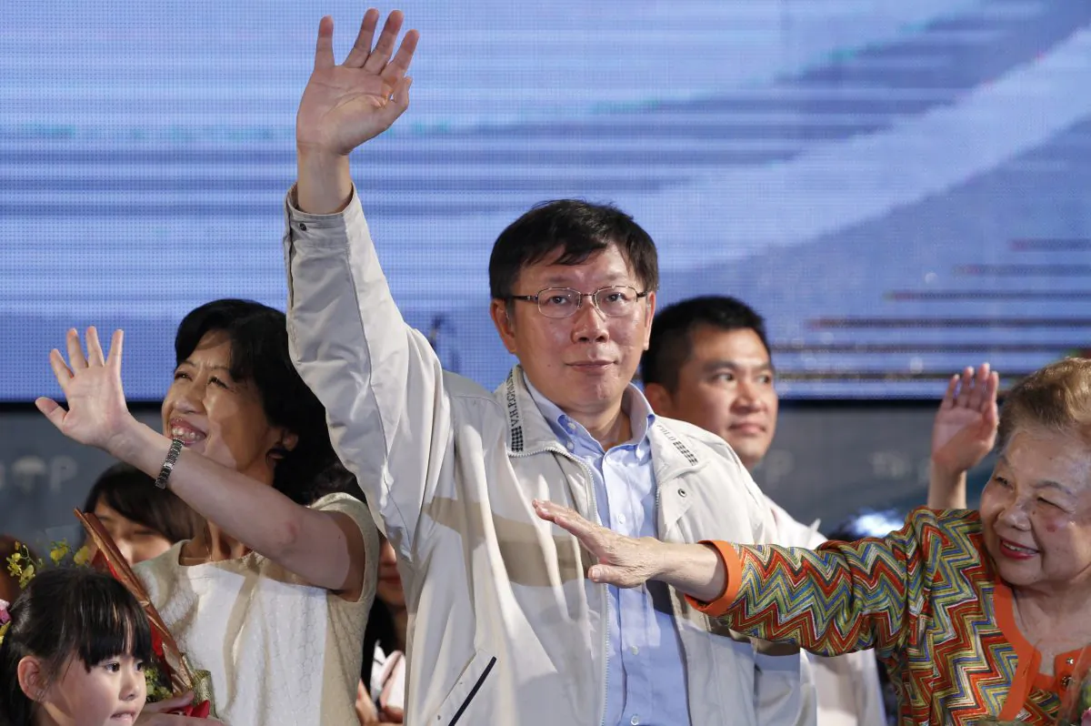 Taipei's new mayor-elect Ko Wen-je, center, waves to supporters at his campaign headquarters in Taipei, Taiwan, Saturday, Nov. 29, 2014. (AP Photo/Wally Santana)