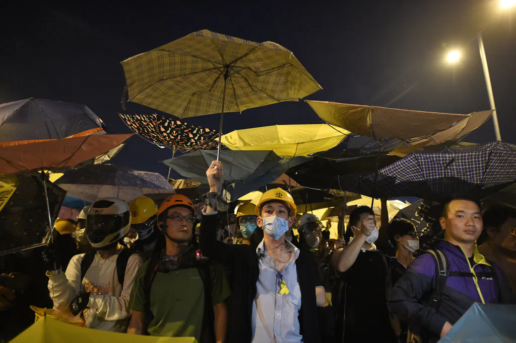 Demonstrators hold umbrellas, a symbol of the pro-democracy protests, amid a clash with police during the protest near the government headquarters in Hong Kong on Nov. 30, 2014. Protesters want free elections in 2017 for Hong Kong's leader, whom Beijing says must be vetted through a loyalist committee. (Philippe Lopez/AFP/Getty Images)