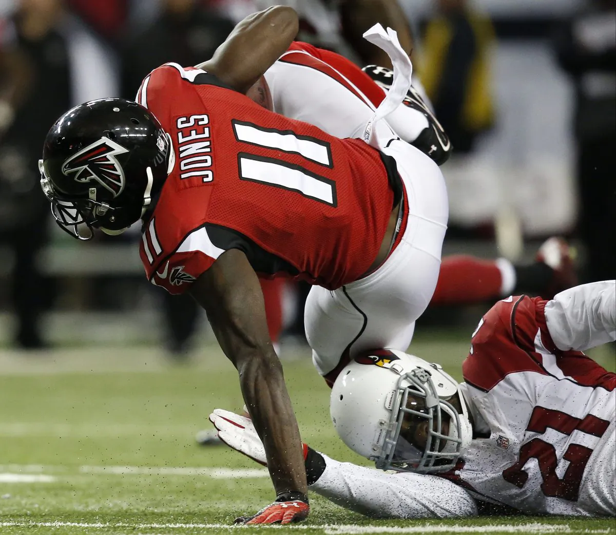Atlanta Falcons wide receiver Julio Jones (11) runs over Arizona Cardinals cornerback Patrick Peterson (21)during the first half of an NFL football game, Sunday, Nov. 30, 2014, in Atlanta. (AP Photo/Brynn Anderson)