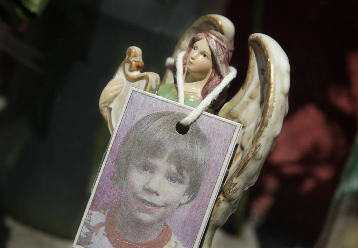 A photograph of Etan Patz hangs on an angel figurine, which is part of a makeshift memorial in the SoHo neighborhood of New York, May 28, 2012. (AP Photo/Mark Lennihan)