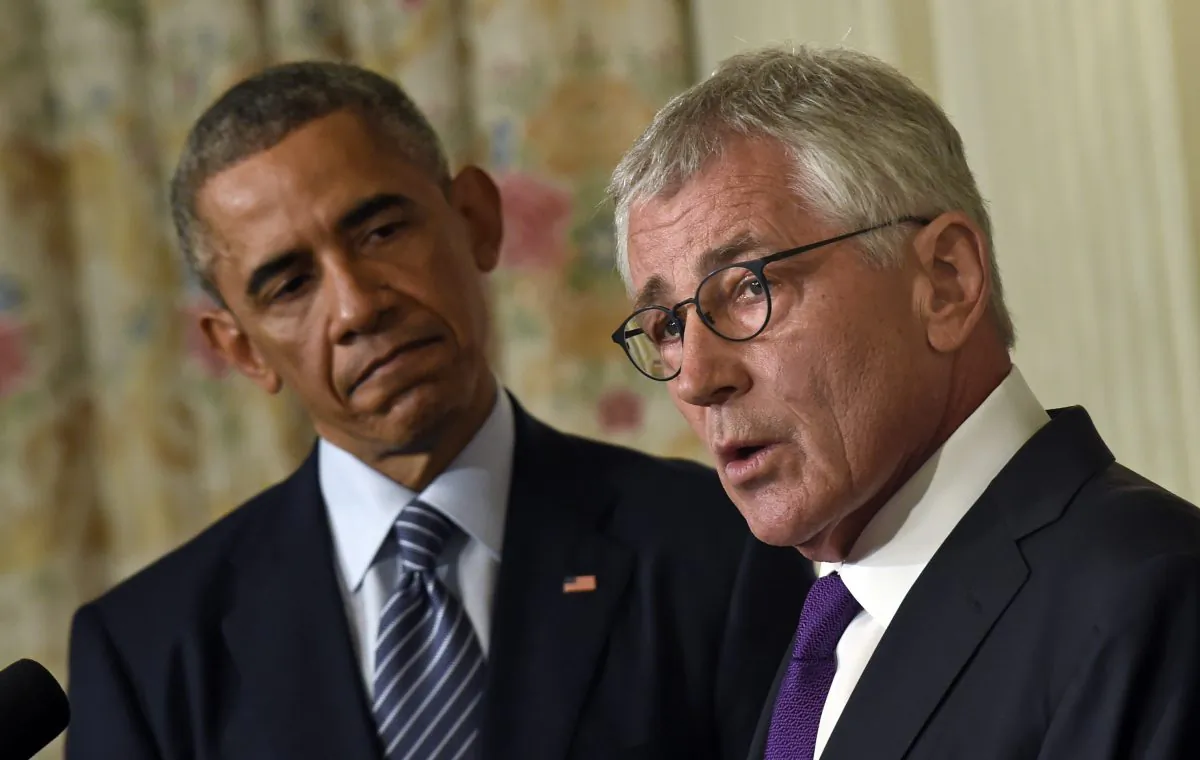 President Barack Obama looks to Defense Secretary Chuck Hagel as Hagel talks about his resignation during an event in the State Dining Room of the White House in Washington, Nov. 24, 2014. (AP Photo/Susan Walsh)