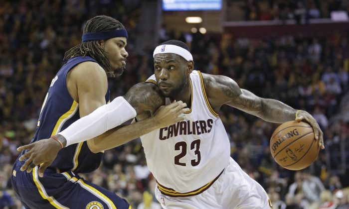 Cleveland Cavaliers' LeBron James, right, drives past Indiana Pacers' Chris Copeland  during the third quarter of an NBA basketball game Saturday, Nov. 29, 2014, in Cleveland. The Cavaliers defeated the Pacers 109-97. (AP Photo/Tony Dejak)