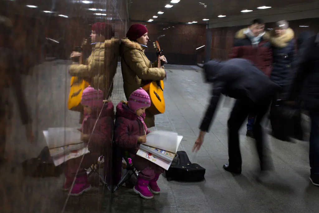 Ksenya, a street musician from a village in Kaluga region, about 160km (100 miles) from Moscow, plays guitar to earn money in an underground subway with her daughter in Moscow, Russia, on Dec. 17, 2014. She earns about 3000 Rubles (about $ 46 USD) a day and works a few days a month to make ends meet. The ruble’s fall, the plunge in world oil prices and the sanctions’ denial of access to Western credit have all dealt a blow to the Russian economy. (AP Photo/Alexander Zemlianichenko)