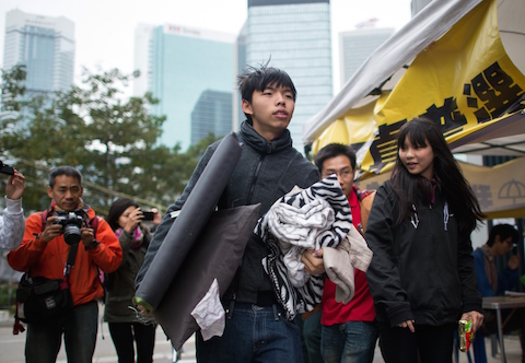 Joshua Wong (C), the teenage face of Hong Kong's pro-democracy movement, carries his belongings towards his tent at the movement's main protest site in the Admiralty district of Hong Kong on Dec. 2, 2014. (Johannes Eisele/AFP/Getty Images)