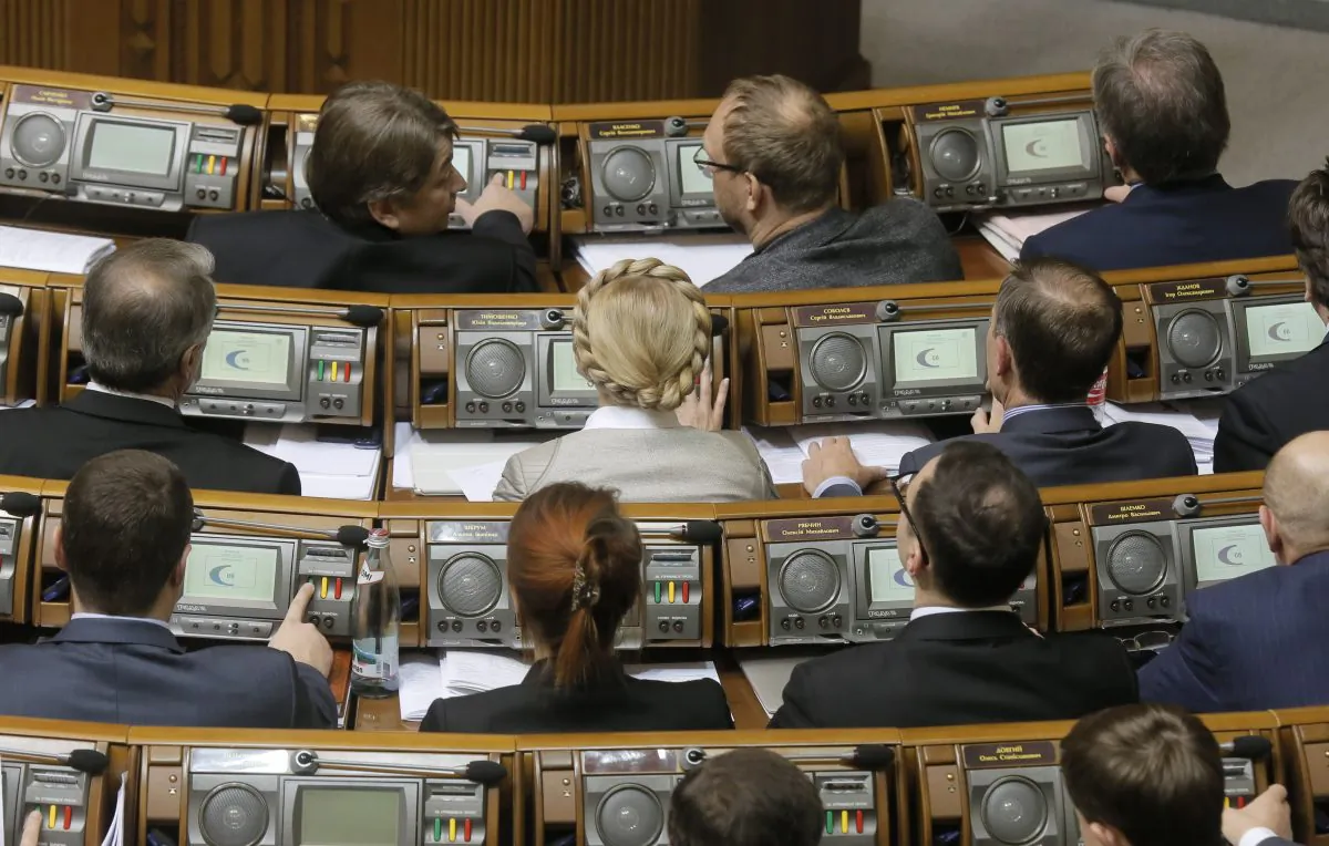 Former Prime Minister and leader of the Fatherland party Yulia Tymoshenko (C) and lawmakers from her party vote during a parliament session in Kiev, Ukraine, Tuesday, Dec. 2, 2014. Ukraine's parliament has approved the formation of a new government, bringing an end to weeks of behind-the-scenes political wrangling following an October election that ushered in a group of ardently pro-Western parties. (AP Photo/Efrem Lukatsky)