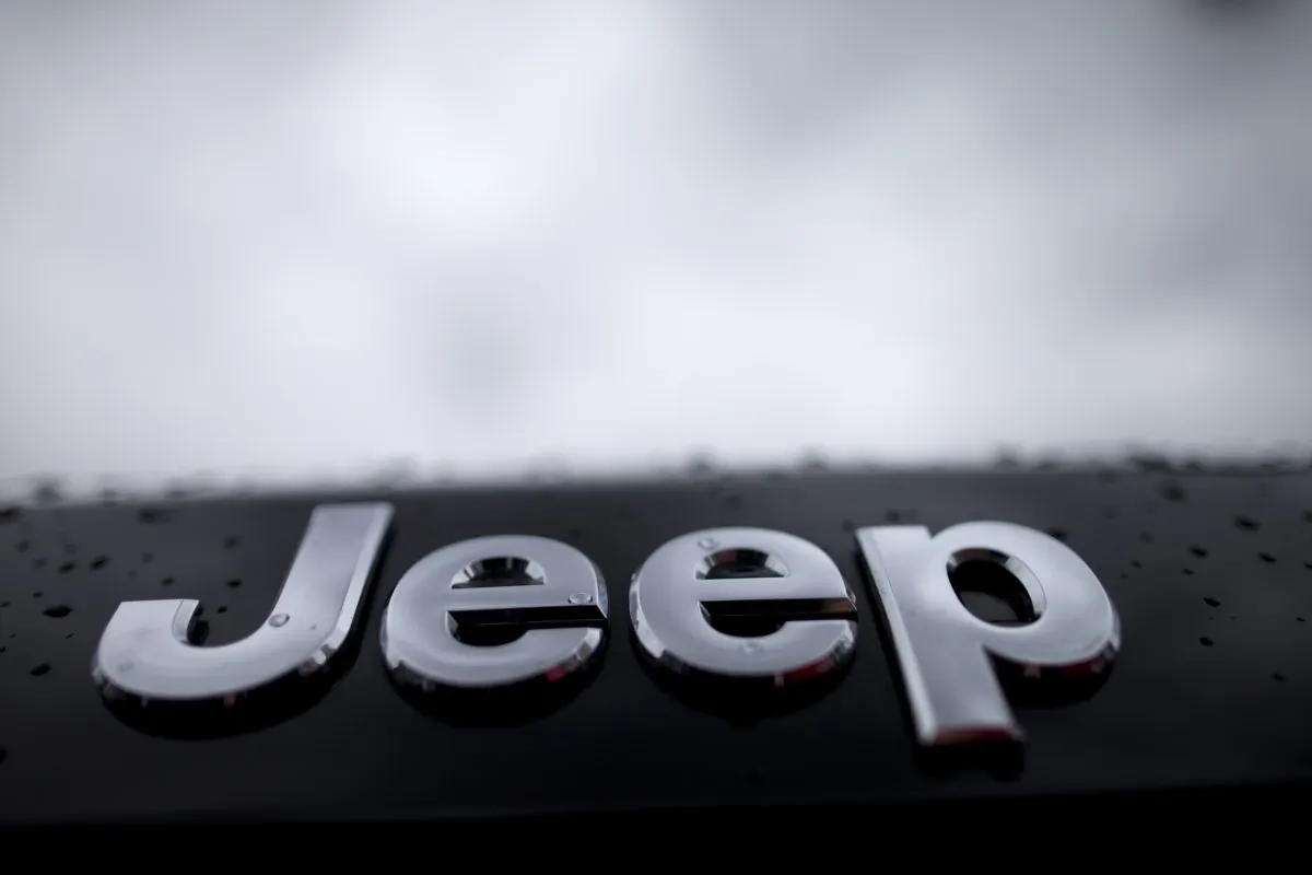 Rain drops dot the Jeep emblem on a Grand Cherokee SUV at a dealership lot Tuesday, Dec. 2, 2014, in San Diego. Black Friday promotions — coupled with falling gas prices, low-interest loans and hot new vehicles — drove US auto sales higher in November, kicking off what's expected to be a strong holiday season. Chrysler, which sells Jeep cars, posted its best November in 13 years. (AP Photo/Gregory Bull)