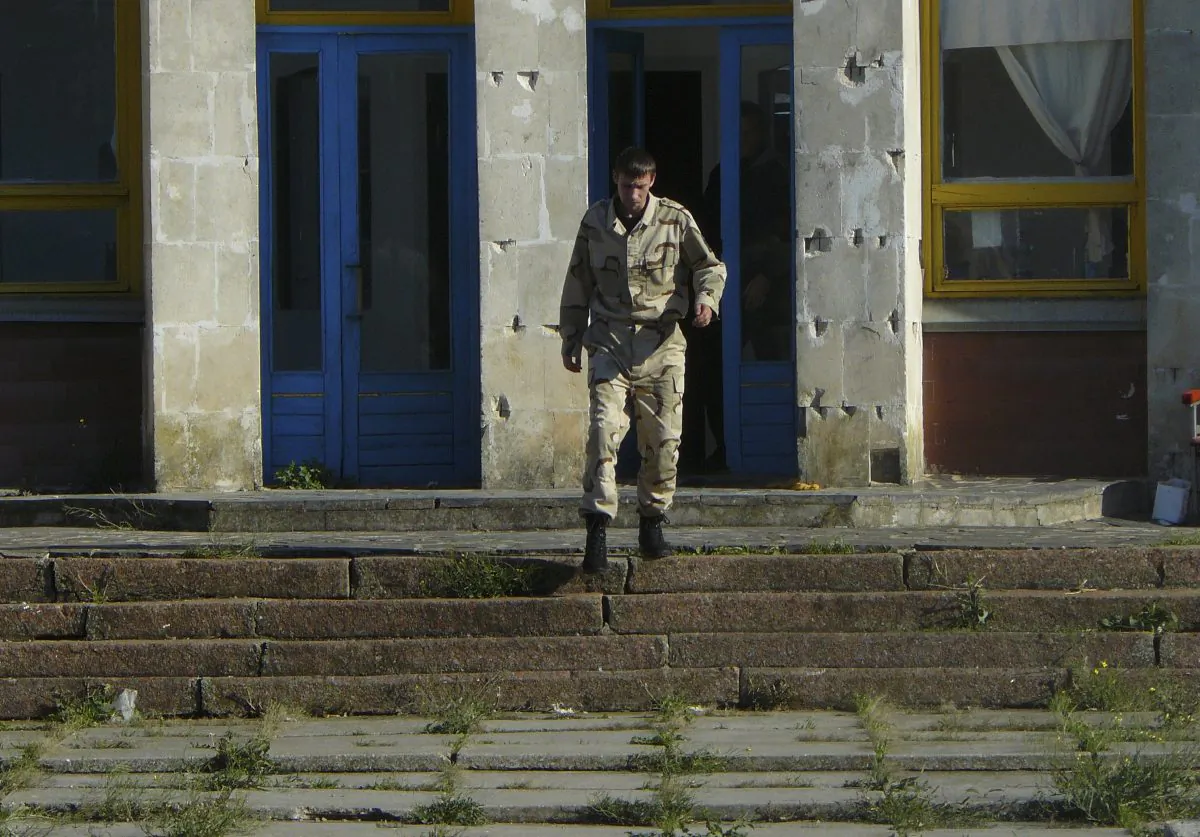 A man in camouflage guards and chases away any would-be visitors at the Dobrobut farm in Grabovo, Crimea, on Oct. 28, 2014. Dobrobut was one of dozens of businesses to be forcibly taken over this year by Crimea’s new pro-Moscow leaders. (AP Photo/Laura Mills)
