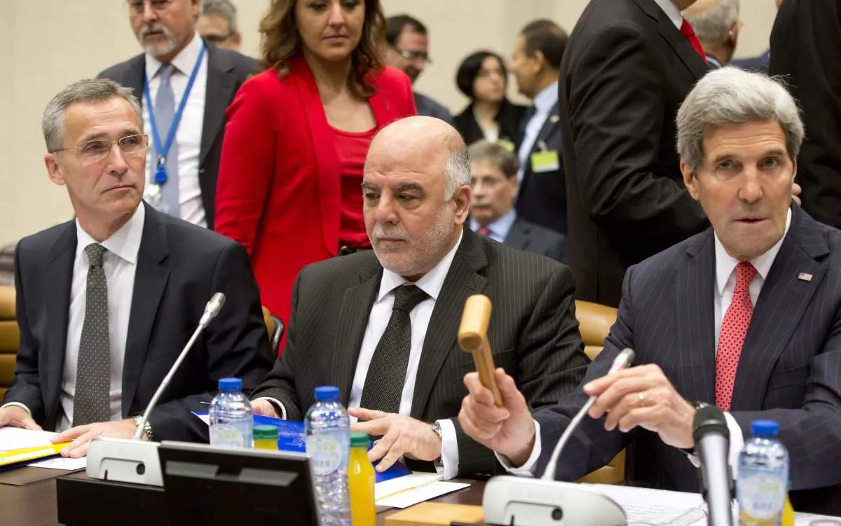 U.S. Secretary of State John Kerry (R) hits the gavel as he presides a meeting as Iraqi Prime Minister Haider al-Abadi (C), and NATO Secretary General Jens Stoltenberg attend the round table meeting of the global coalition to counter the Islamic State militant group at NATO headquarters in Brussels on Wednesday, Dec. 3, 2014. Kerry opened on Wednesday a high-level meeting at NATO headquarters of countries participating in the campaign against the Islamic State organization to assess what’s been accomplished and what remains to be done. (AP Photo/Virginia Mayo)