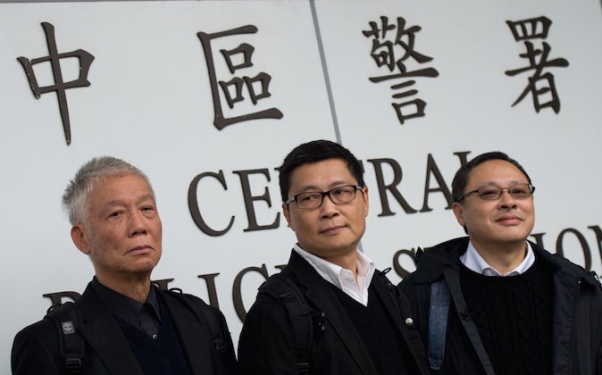 Benny Tai (R), an original founder of the pro-democracy Occupy movement, Chu Yiu-ming (L) and Chan Kin-man surrender to police in Hong Kong on December 3, 2014. (Johannes Eisele/AFP/Getty Images)