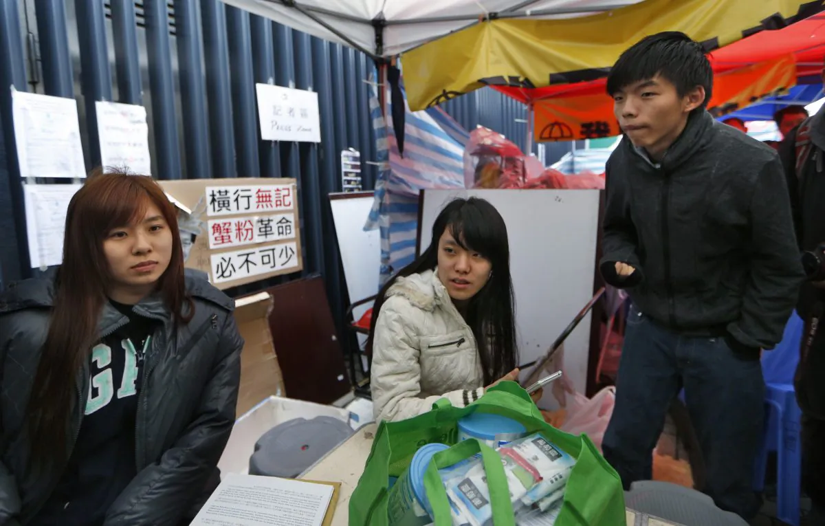Three students, Joshua Wong (R), Prince Wong (C) and Isabella (L) Lo talk to the media during their hunger strike next to their tent at the occupied area outside government headquarters in Hong Kong Tuesday, Dec. 2, 2014. (AP Photo/Kin Cheung)