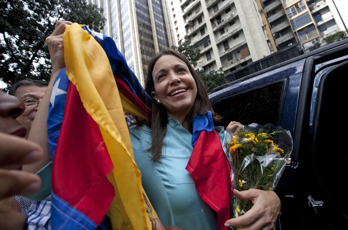Former Congresswoman and opposition leader Maria Corina Machado holds up the Venezuelan flag outside of the Attorney General Office in Caracas, Venezuela, on Dec. 3, 2014. (Ariana Cubillos/AP Photo)