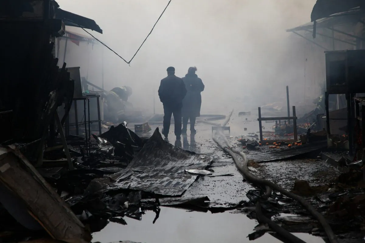 People walk past burnt out kiosks at a street market close to a destroyed building housing the housing the local media known as the Press House, in central Grozny, on Dec. 4, 2014. Heavily-armed gunmen attacked a police post killing several officers before storming a building housing the local media and a school in the capital. (Elena Fitkulina/AFP/Getty Images)