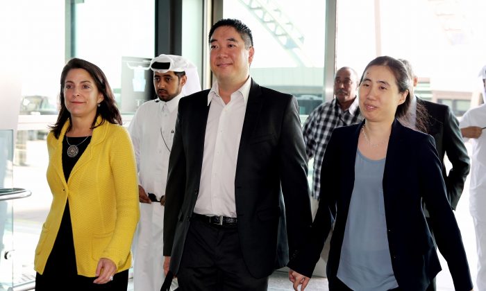 American couple Grace, right, and Matthew Huang walk to their departure gate with U.S. Ambassador to Qatar, Dana Shell Smith, left, at the Hamad International Airport in Doha, Qatar, on Nov. 30, 2014. After nearly two years of detention in the Gulf country, the couple were relieved of all charges but were prevented from leaving the country. (Osama Faisal/AP Photo)