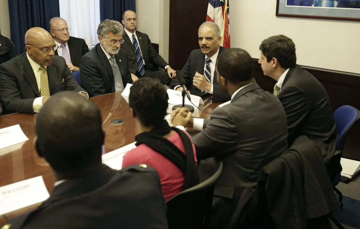 U.S. Attorney General Eric Holder holds a roundtable meeting with law enforcement, local officials, and community leaders in Cleveland on Thursday. (AP Photo/Tony Dejak)