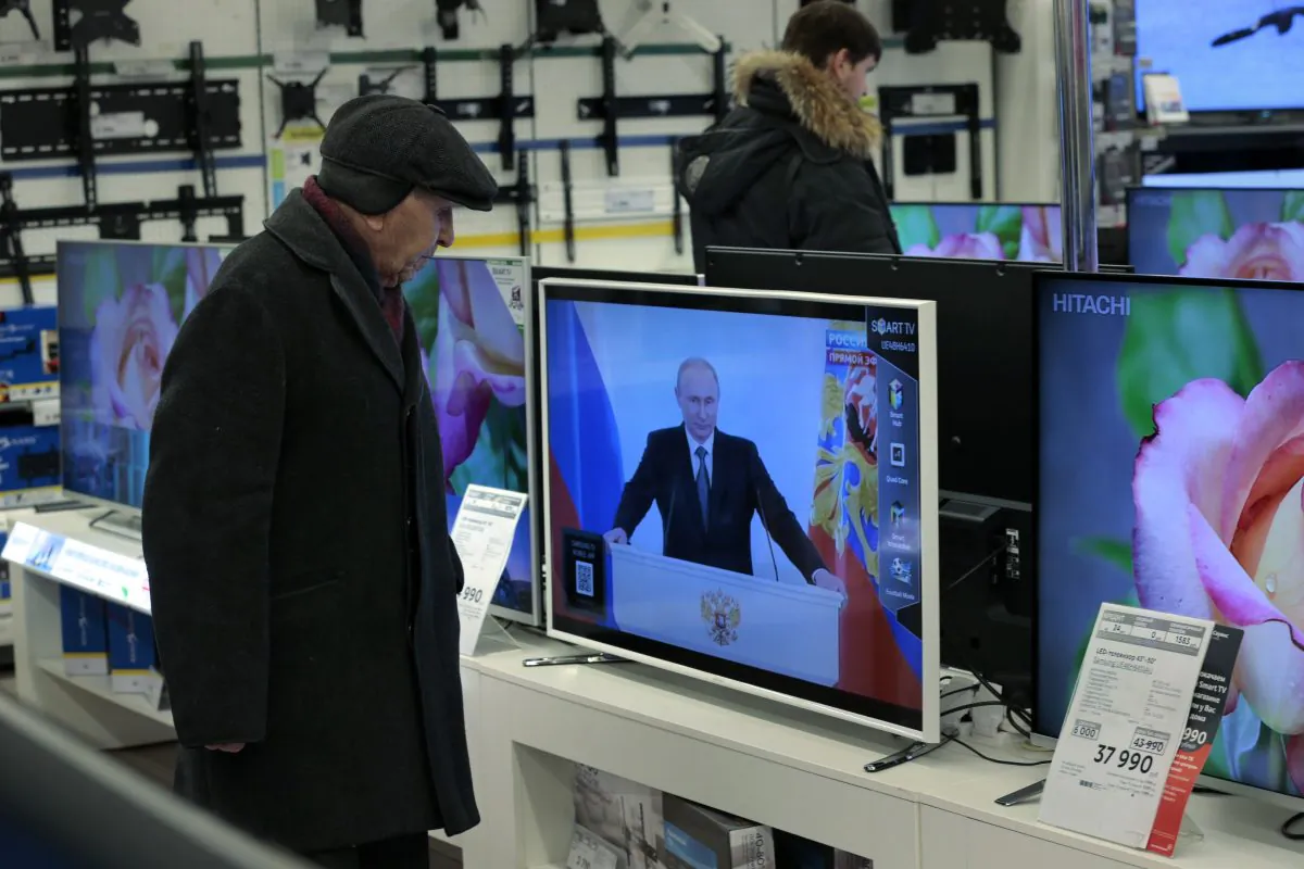 Customers look at TV sets with Russian President Vladimir Putin, at a shop in Moscow, Russia, on Thursday, Dec. 4, 2014, during his annual state of the nation address in the Kremlin. Russian President Vladimir Putin has defended the Kremlin's aggressive foreign policy, saying the actions are necessary for his country's survival. (AP Photo/Ivan Sekretarev)