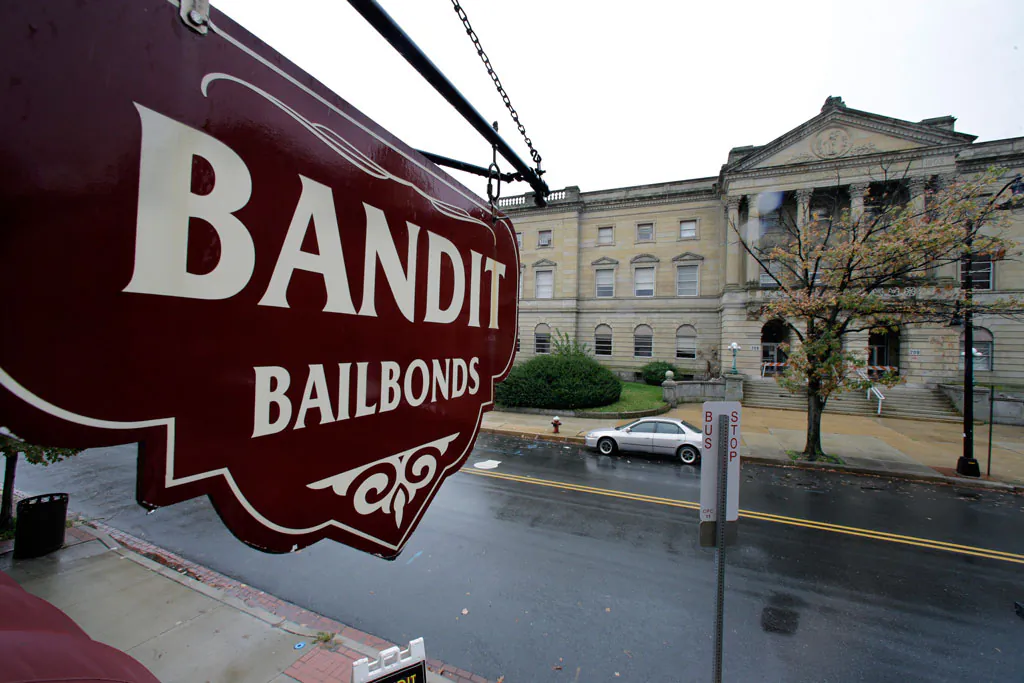 A sign is seen outside a bail bondsman across the street from Mercer County criminal courthouse in Trenton, N.J., on Oct. 23, 2014. In courtrooms across the country every day, a price tag is put on freedom and for many it’s too expensive. With more than 60 percent of inmates in jails nationwide awaiting trial and many unable to afford bail, some states and counties are looking at overhauling the system so it’s based less on money and more on holding dangerous defendants. Earlier this year, New Jersey became the latest state to adopt a system that bases bail on a risk analysis of each defendant. (AP Photo/Mel Evans)