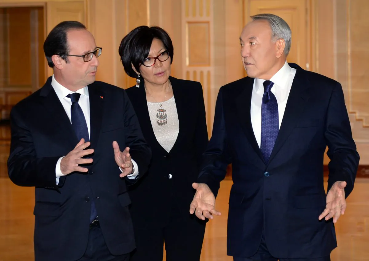 Kazakh President Nursultan Nazarbayev (R) and French President Francois Hollande speak during their meeting in Astana, Kazakhstan, Friday, Dec. 5, 2014. Unidentified aid as centre. (AP Photo/Sergei Bondarenko, Presidential Press Service)