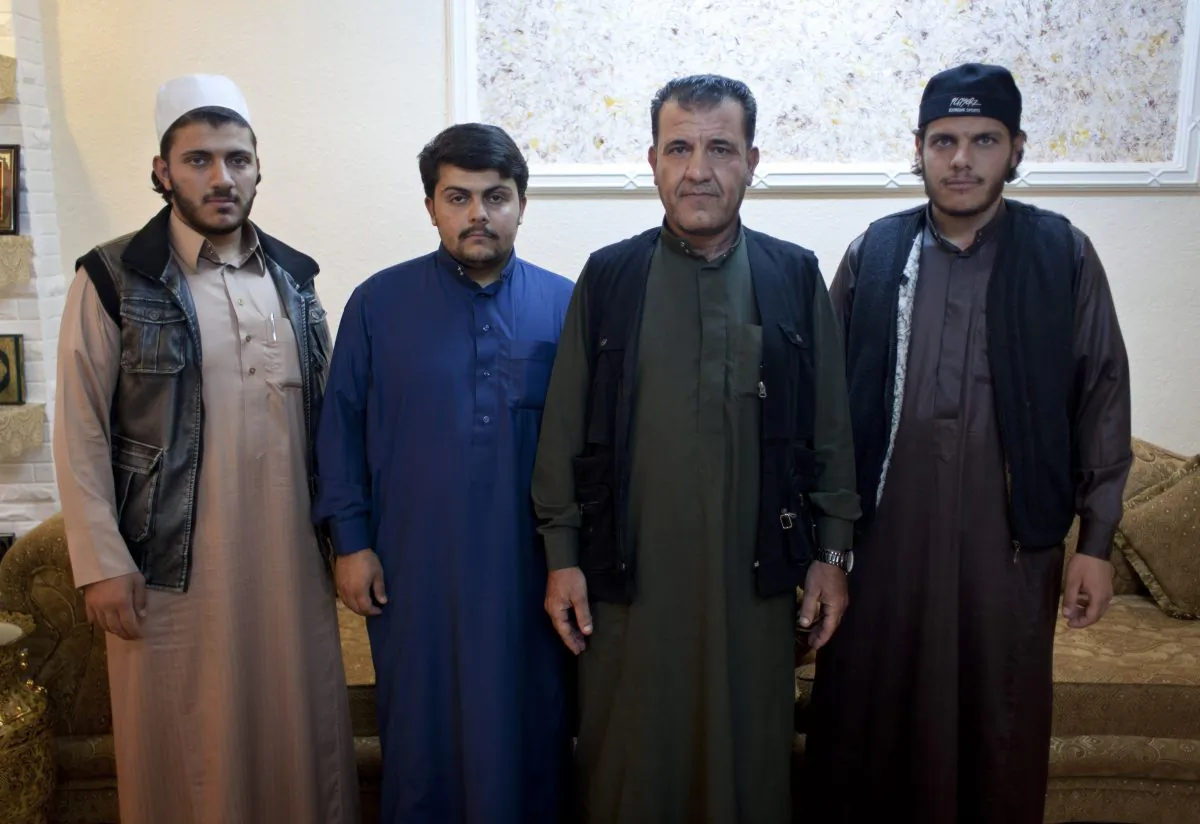 Omar Mansour (2L), 23, who briefly joined jihadists in Syria, and his brother Abdullah (R), 21, recruited to join al-Qaeda in Yemen, pose for a photo with their brother Ahmed (L), 19, and their father Mahmoud, 48, at the family house, in the city of Ma'an, Jordan, on Oct. 28, 2014. Now they are home, trying to live ordinary lives, but believe their hardline vision of Islam is gaining popularity. (AP Photo/Nasser Nasser)