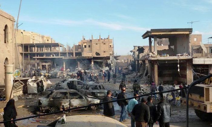 A burned cars and damaged buildings on a street after Syrian government forces airstrikes struck a popular market near a museum and an industrial neighborhood in Raqqa city, north Syria, on Nov. 25, 2014. The death toll from a series of Syrian government airstrikes on the Islamic State group's stronghold in northeastern Syria has risen to at least 150, making it one of the deadliest attacks on the city of Raqqa in the past three years. (AP Photo/Raqqa Is Being Slaughtered Silently)