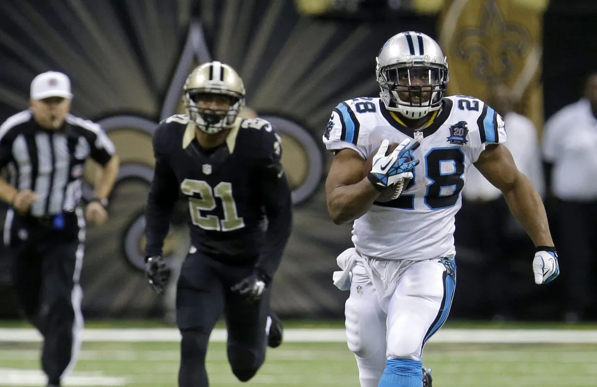 Carolina Panthers running back Jonathan Stewart (28) runs on a 69-yard touchdown carry as New Orleans Saints cornerback Patrick Robinson (21) pursues in the second half of an NFL football game in New Orleans, Sunday, Dec. 7, 2014. (AP Photo/Bill Feig)