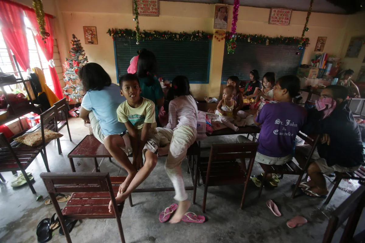 Evacuees stay inside a school as Typhoon Hagupit affects Legazpi, Albay province, eastern Philippines on Sunday, Dec. 7, 2014. (AP Photo/Aaron Favila)