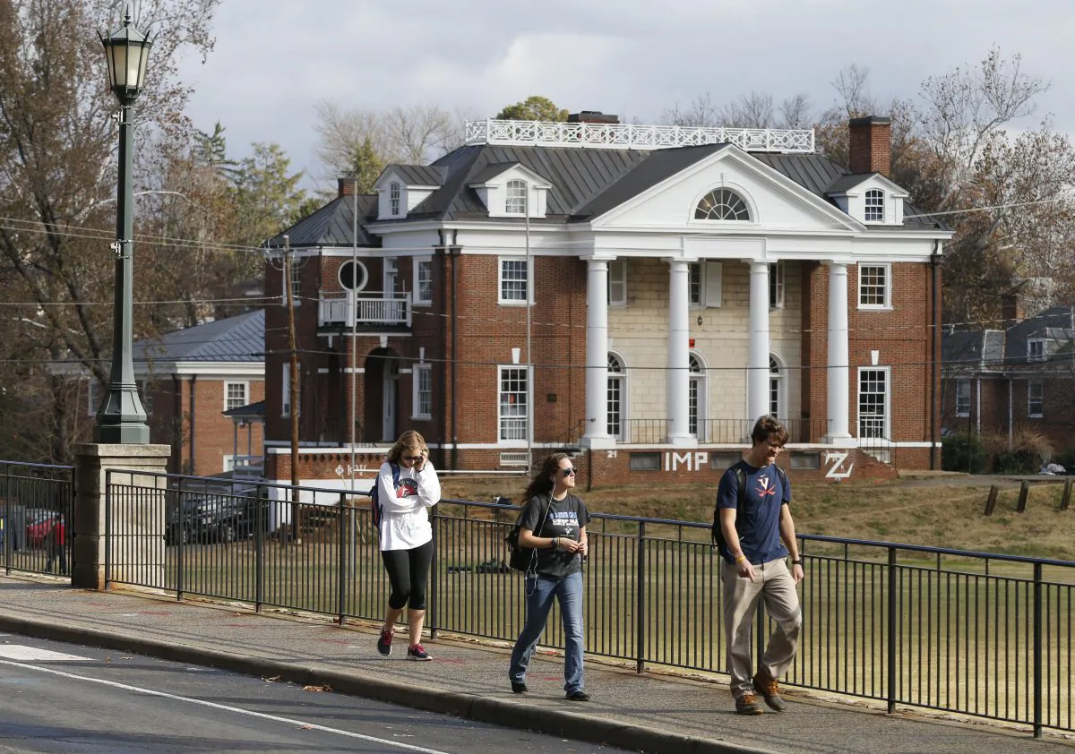 Students walk to campus past the Phi Kappa Psi fraternity house at the University of Virginia in Charlottesville, Va. on Nov. 24. Rolling Stone published a story alleging a rape by seven members of Phi Kappa Psi in November. (AP Photo/Steve Helber)