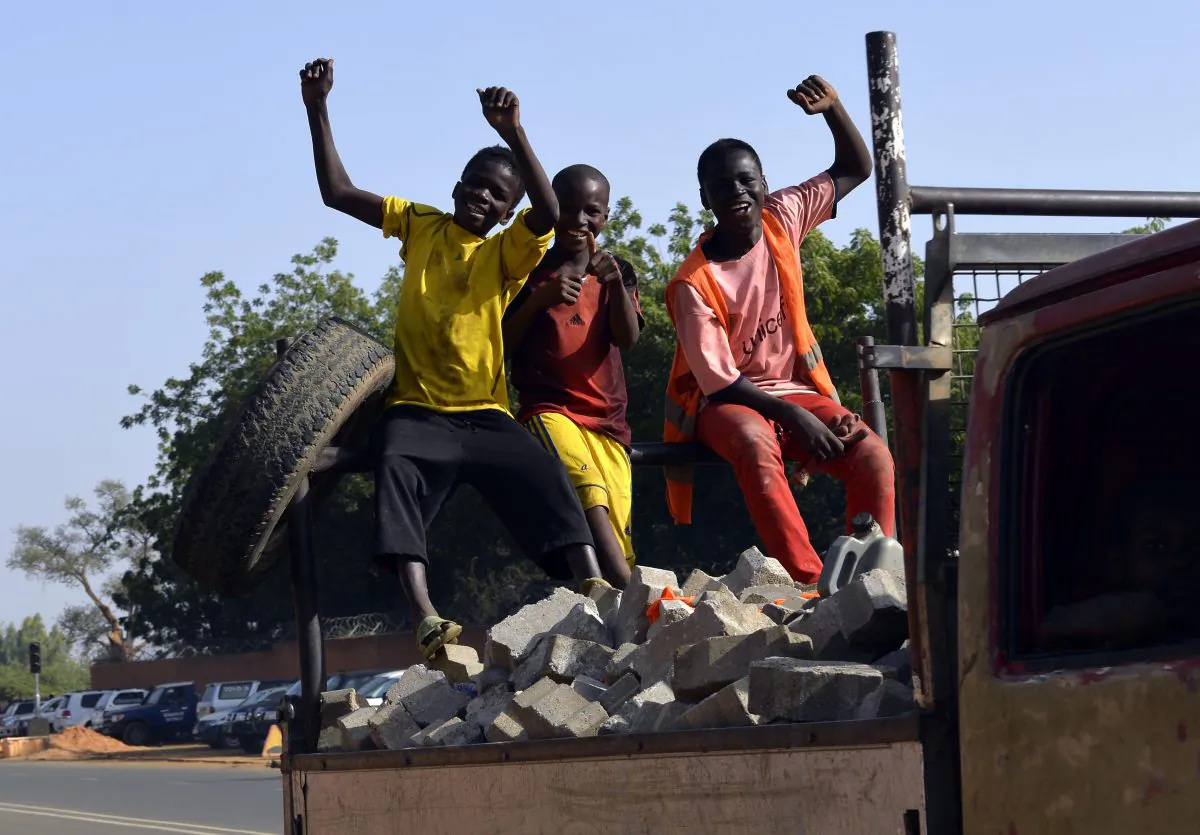 Children cheer while traveling on a truck loaded with stones in Niamey, Niger, on Nov. 23, 2014. (Miguel Medina/AFP/Getty Images)