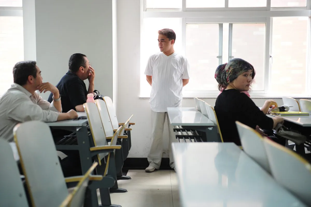 Uyghur professor Ilham Tohti chats with students following his lecture in a classroom in Beijing on June 12, 2010. On Dec. 8, 2014, Seven students of Ilham were sentenced to between three and eight years imprisonment on charges of participating in “secessionist criminal activities.” (Frederic J. Brown/AFP/Getty Images)