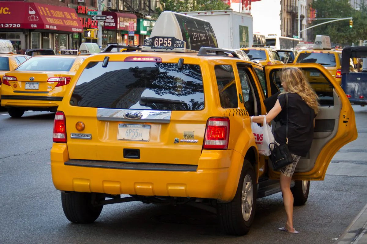 A women gets into a taxi on Seventh Avenue in Manhattan on July 12, 2012. (Benjamin Chasteen/Epoch Times)