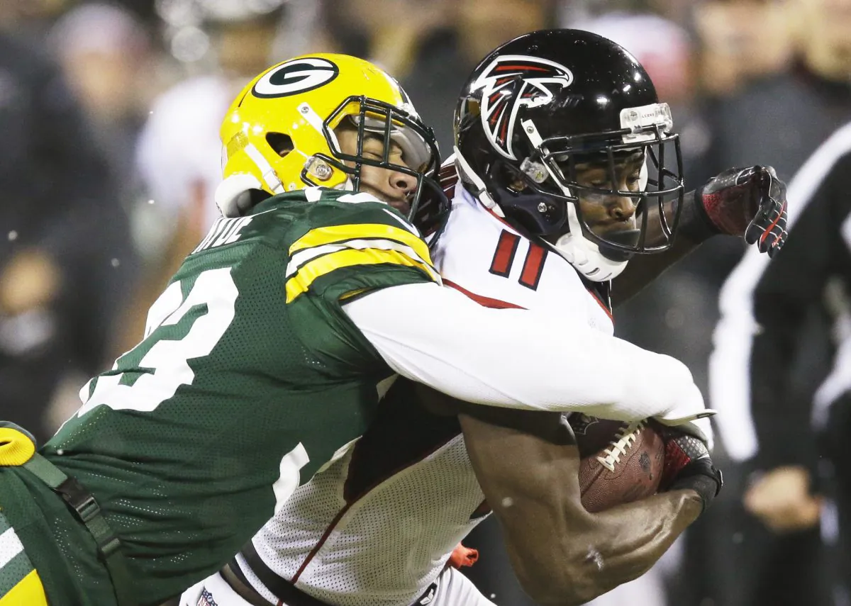 Green Bay Packers' Micah Hyde tackles Atlanta Falcons' Julio Jones (11) after a catch during the first half of an NFL football game Monday, Dec. 8, 2014, in Green Bay, Wis. (AP Photo/Tom Lynn)
