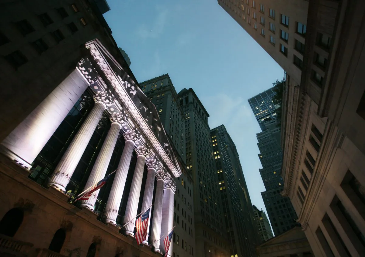 American flags fly in front of the New York Stock Exchange, in New York, on Oct. 8, 2014. U.S. stocks are opening sharply lower Tuesday, Dec. 9, 2014, following a slump in global markets. (AP Photo/Mark Lennihan)
