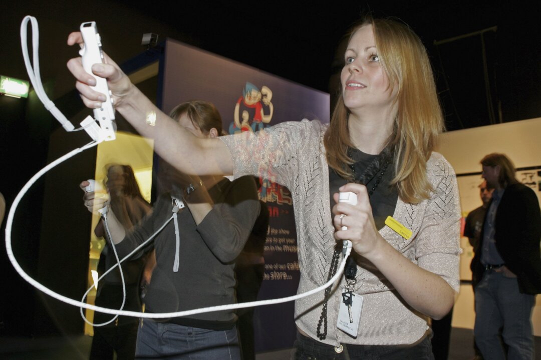 LONDON - NOVEMBER 29: People use wireless controllers to play a boxing game on a Nintendo Wii, during the Game On exhibition at the Science Museum on November 29, 2006 in London, England. The exhibition features a complete line-up of next-generation video gaming hardware, as the Nintendo Wii and Sony Playstation 3 have been installed well ahead of their UK public release. The Nintendo Wii will go on sale on December 8 and the Sony Playstation 3 will be unavailabe in Europe untill March 2007. (Photo by Scott Barbour/Getty Images)