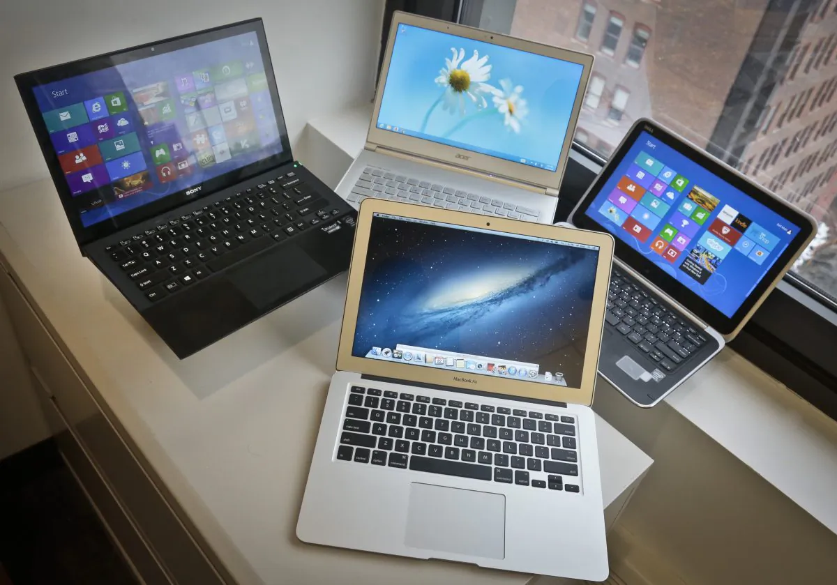 A MacBook Air from Apple, bottom center, a Vaio Pro 13 from Sony, top left, an Aspire S7 from Acer, center, and an XPS 12 from Dell, right, are displayed for a photograph, Thursday, Aug. 22, 2013, in New York. (Bebeto Matthews/AP Photo)