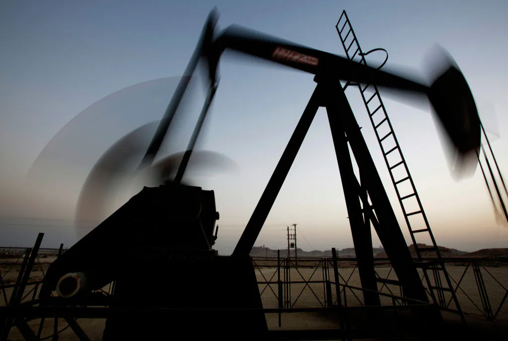 An oil pump works at sunset in the desert oil fields of Sakhir, Bahrain, on Oct. 14, 2014. The price of oil took another sharp tumble Thursday, Nov. 13, 2014, as it appeared increasingly unlikely that OPEC members will cut production to staunch a plunge in prices that is entering its fifth month. (AP Photo/Hasan Jamali)