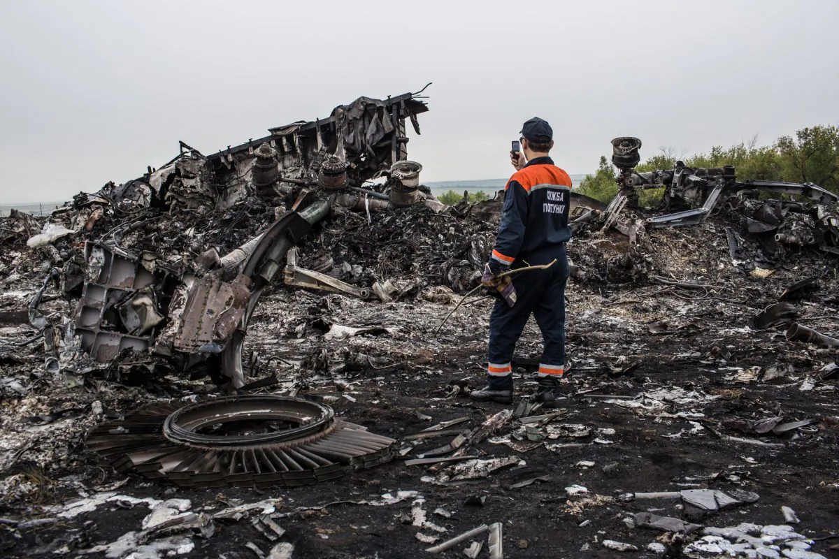 An emergency services worker photographs debris from the crash site of Malaysia Airlines flight MH17 on July 18, 2014 in Grabovka, Ukraine. (Brendan Hoffman/Getty Images)