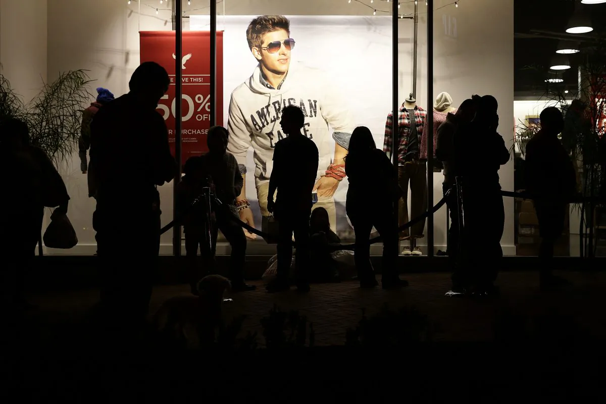 People wait outside the American Eagle store for it to open at the Citadel Outlets in Los Angeles on Nov. 28, 2013. Drops in sales and weak profit forecasts are quite a change for the retailers that gained popularity in the last decade among teens that coveted their logo tees and trendy jeans that became a high school uniform of sorts. But these stores have been losing favor with their core demographic since the recession. (AP Photo/Jae C. Hong)
