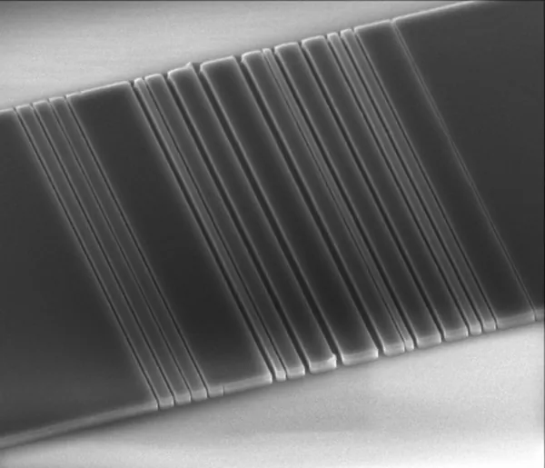 This tiny slice of silicon, etched in Jelena Vuckovic's lab at Stanford with a pattern that resembles a bar code, is one step on the way toward linking computer components with light instead of wires. (Stanford Vuckovic Lab)