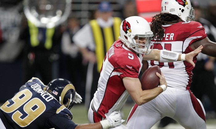 Arizona Cardinals quarterback Drew Stanton (5) runs out of the tackle of St. Louis Rams' Aaron Donald (99) during the first half of an NFL football game Thursday, Dec. 11, 2014 in St. Louis. (AP Photo/Tom Gannam)
