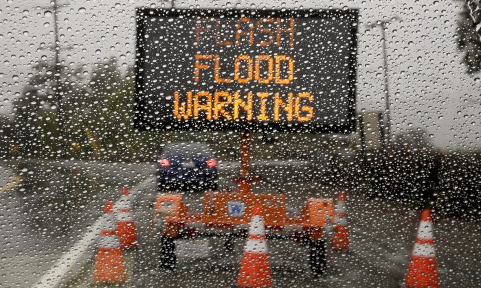A sign warning of floods stands at the entrance to Silverado Canyon due to the potential for mud slides at a recent burn area in Silverado Canyon, Calif., Friday, Dec. 12, 2014.(Chris Carlson/AP Photo)