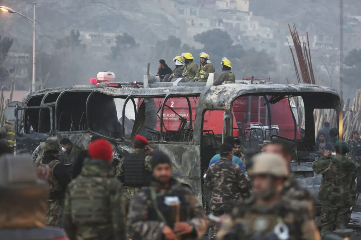 Afghan security personnel inspect a damaged bus at the site of a suicide attack by the Taliban in Kabul, Afghanistan, on Dec. 13, 2014. (AP Photo/Rahmat Gul)