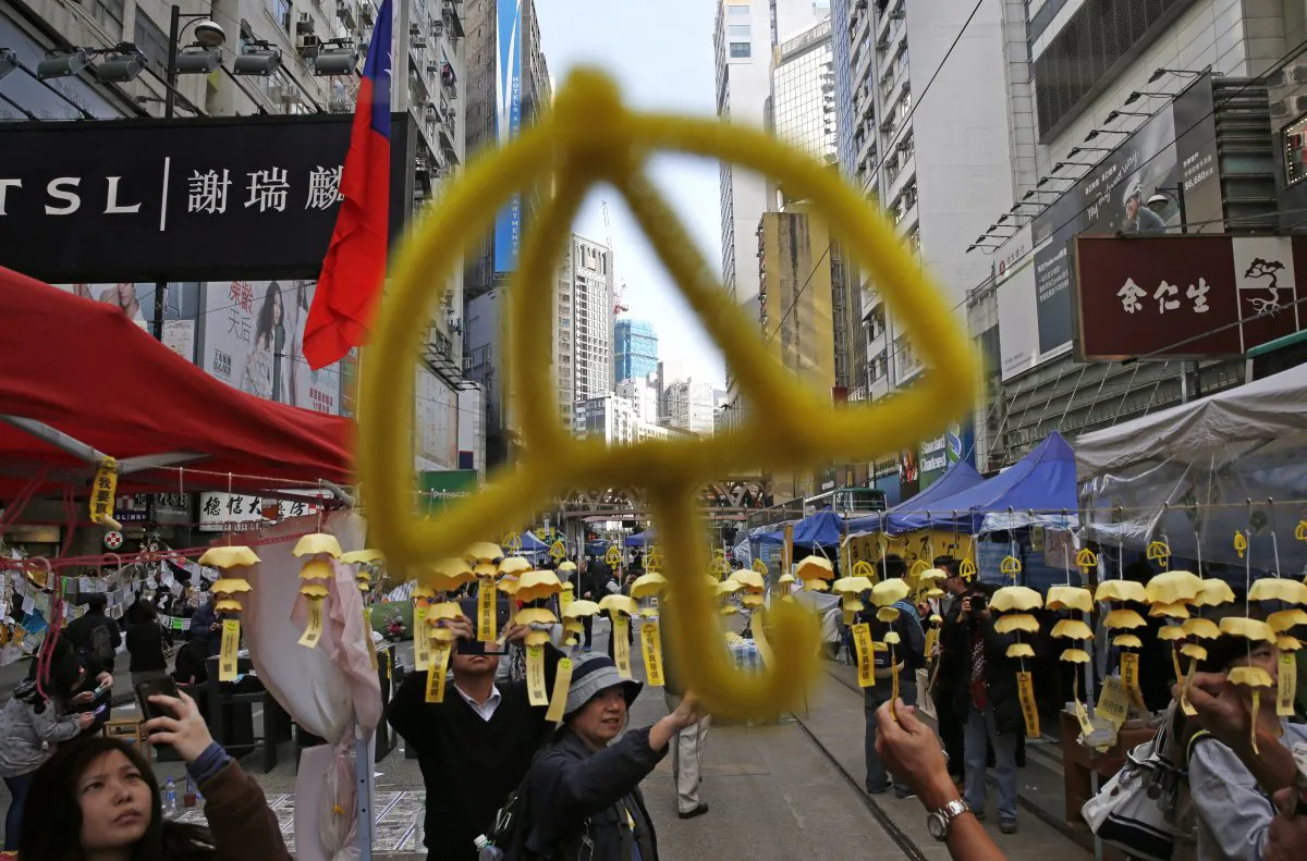Yellow umbrella decorations are hanged by protesters in the Causeway Bay shopping district, one of the occupied areas by pro-democracy protesters in Hong Kong Saturday, Dec. 13, 2014. (AP Photo/Kin Cheung)