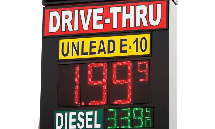 A sign displays the price for E-10 gasoline for $1.99 at the OnCue convenience store and gas station in Oklahoma City on Dec. 3, 2014. With oil prices now around a five-year low, budget officials in about a half-dozen states already have begun paring back projections for a continued gusher of revenues and more could be necessary if oil prices stay at lower levels. (AP Photo/The Oklahoman, Paul B. Southerland)