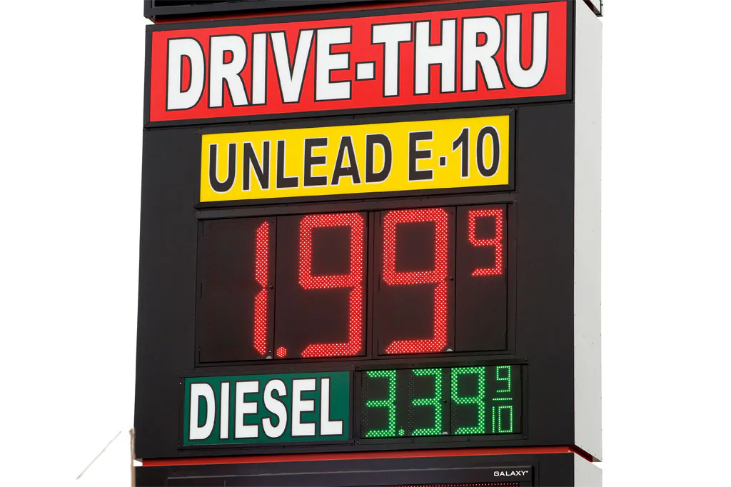 A sign displays the price for E-10 gasoline for $1.99 at the OnCue convenience store and gas station in Oklahoma City on Dec. 3, 2014. With oil prices now around a five-year low, budget officials in about a half-dozen states already have begun paring back projections for a continued gusher of revenues and more could be necessary if oil prices stay at lower levels. (AP Photo/The Oklahoman, Paul B. Southerland)