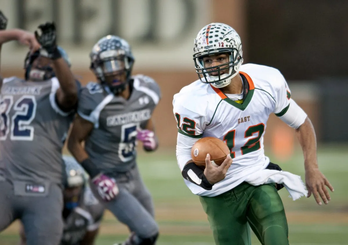 East Lincoln quarterback Chazz Surratt carries the ball during the NCHSAA 2AA State Championship high school football game held in Winston-Salem, N.C. Saturday, Dec. 14, 2014. (AP Photo/Winston-Salem Journal, Lauren Carroll)