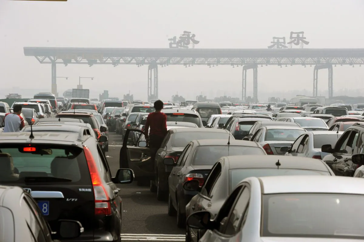 Chinese motorists get out of their cars to check on a massive traffic jam at a toll booth on the outskirts of Beijing on Oct. 2, 2010. In 2014 an estimated 400 billion yuan in tolling fees was paid by Chinese drivers, and many have questioned the legality of current toll policies. (STR/AFP/Getty Images) 