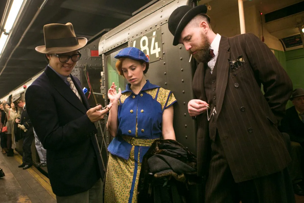 People donning early- and mid-20th century fashion stand in the doorway of a vintage MTA subway train, which only runs during the holidays, in Manhattan on Dec. 14, 2014. The event includes live jazz bands and dancing. (Benjamin Chasteen/Epoch Times)