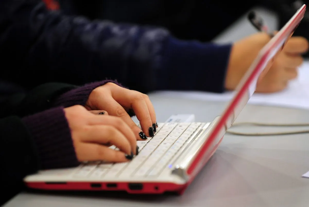 A woman types on her laptop in Beijing. Leaked emails show the Chinese regime employs at least 500,000 paid commentators in its "Fifty Cent" army. (Frederic J. Brown/AFP/Getty Images) 