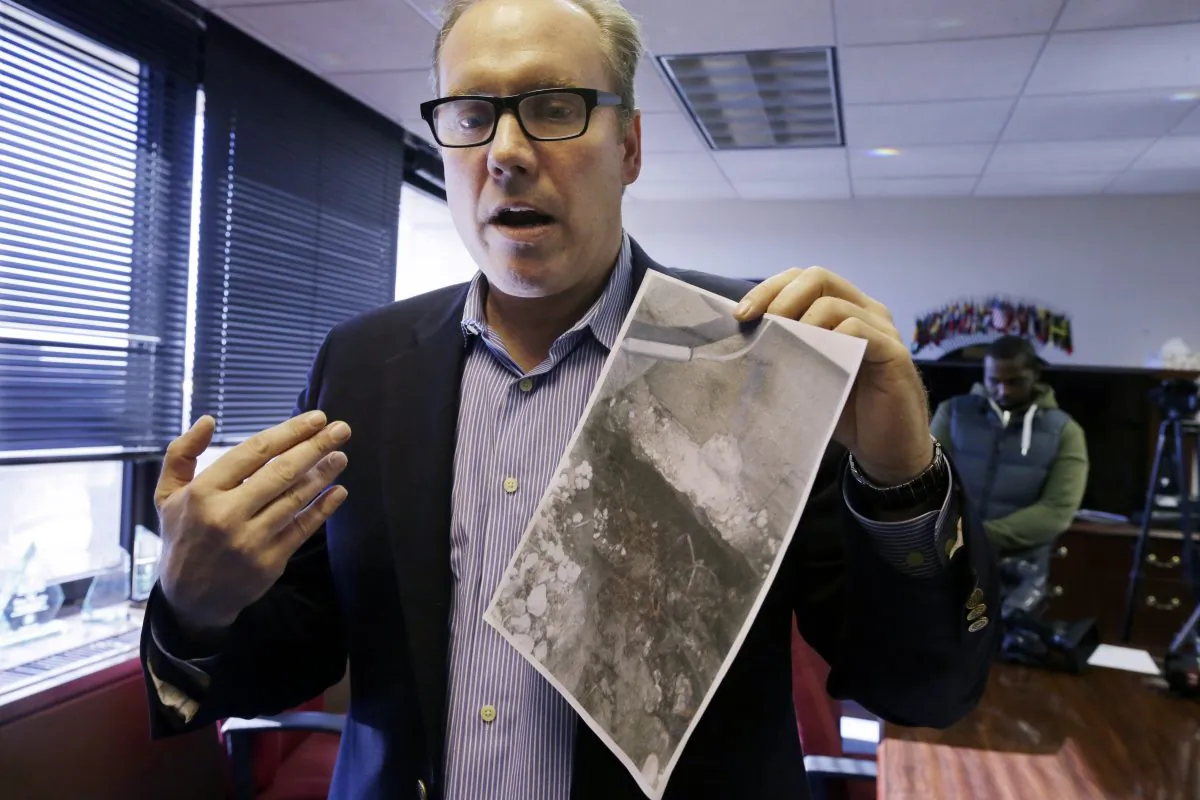 Toms River, N.J., resident Douglas Quinn in Newark, N.J., on Nov. 14, 2014, showing a photo of damage to his home after Superstorm Sandy. He says that his insurance company now says that the damage was pre-existing and refuses his claim. (AP Photo/Mel Evans)