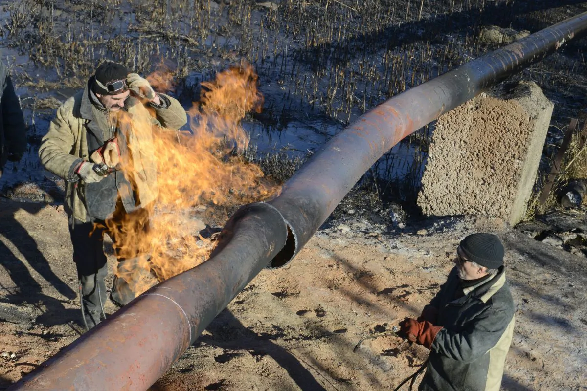 Workers repair a gas pipeline damaged during shelling between Ukrainian forces and pro-Russian militants in the eastern Ukrainian village Krasnyi Pakhar in the Donetsk region on Nov. 23, 2014. (Alexander Khudoteply/AFP/Getty Images)